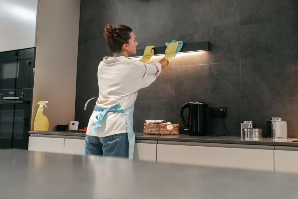 Young, dark-haired woman cleaning a kitchen lamp in and near Syosset